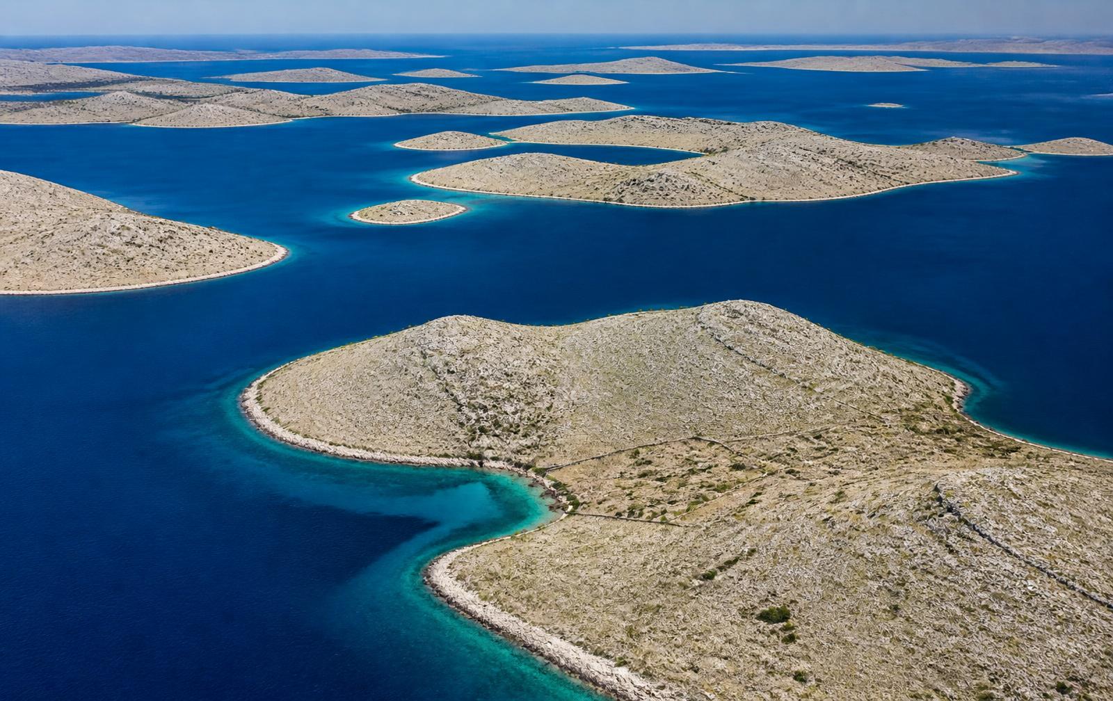 Aerial view of the bare limestone islands of the Kornati archipelago in deep blue sea